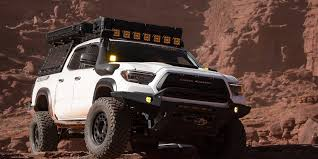 Black Toyota Tacoma pickup truck on snow-capped mountain overlanding trail