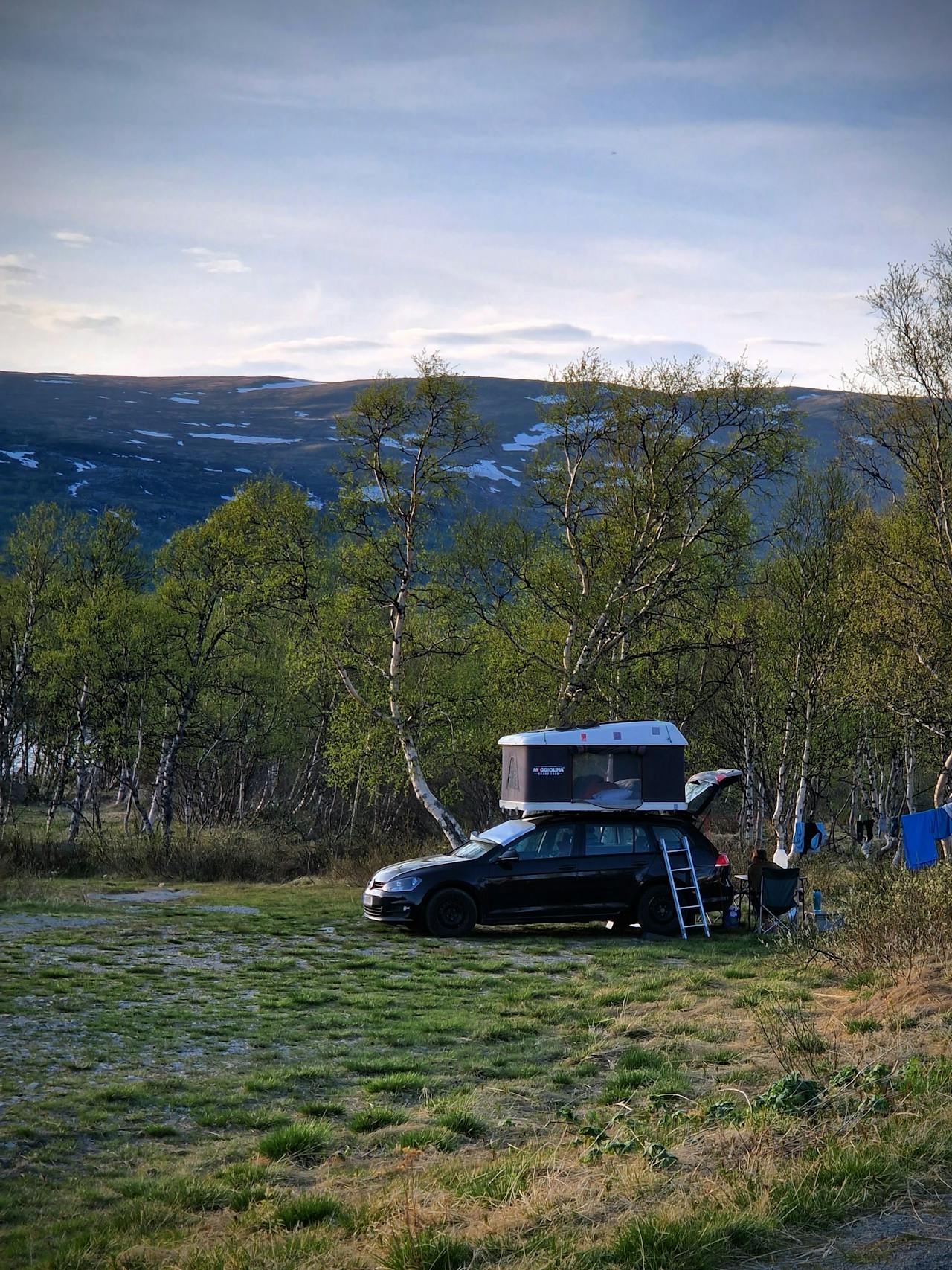 Brown SUV with rooftop tent in mountains
