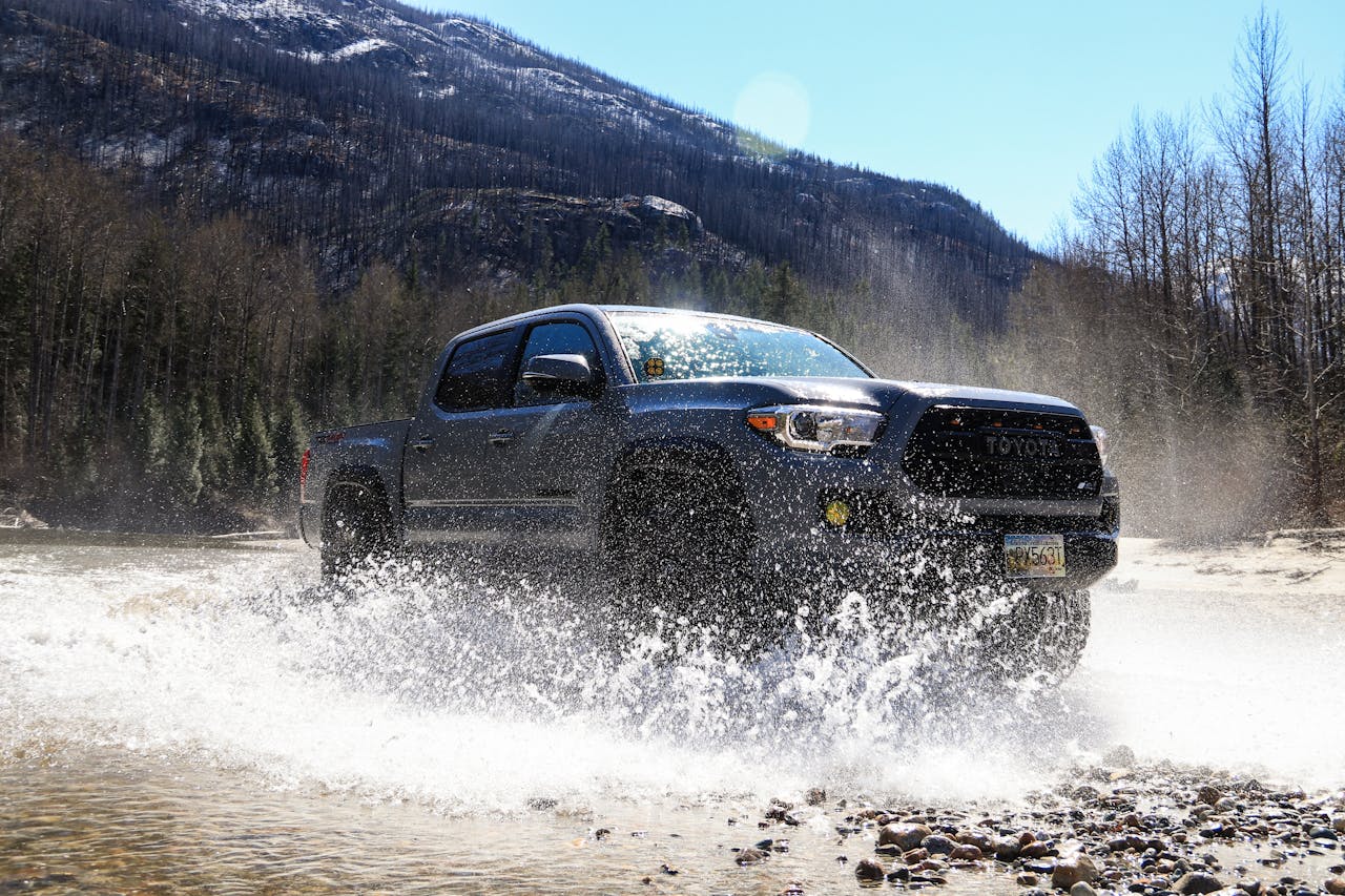 Black Toyota Tacoma pickup truck on mountain overlanding trail